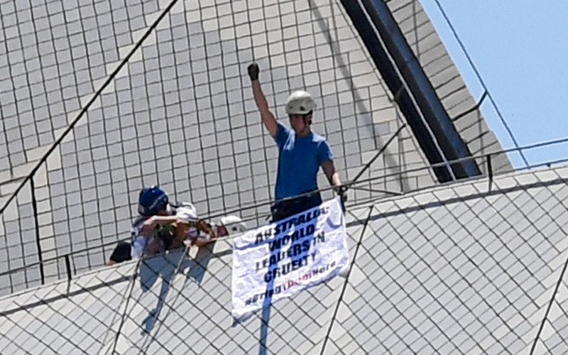 ناشطون يرفعون لافتة تحمل عبارة «أستراليا الرائدة عالمياً في القسوة» أعلى دار أوبرا سيدني