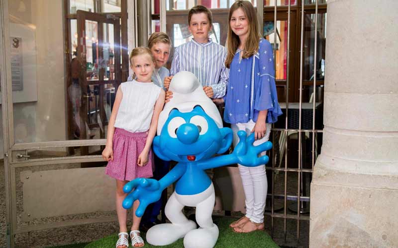 العاهل البلجيكي الملك فيليب يلتقط صورة لعائلته في مركز رسوم الكارتون وأمامهم إحدى شخصيات مسلسل وفيلم الرسوم المتحركة الشهير "السنافر".