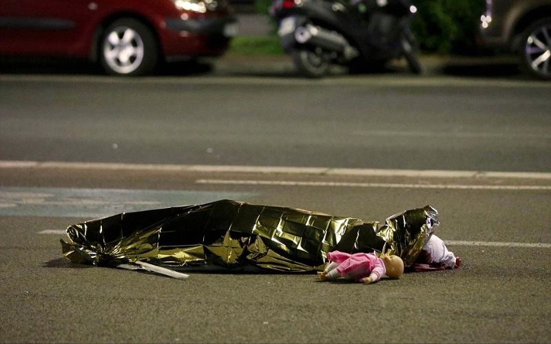 جثة ملقاة على الأرض بجانب دمية على خلفية حادثة الهجوم الإرهابي بشاحنة أثناء تجمع الناس لمشاهدة الألعاب النارية في العيد الوطني في نيس.فرنسا.يوليو