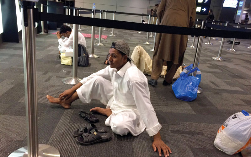 مسافرون في مطار حمد الدولي بانتظار رحلة جوية بعد أن أغلقت السعودية ودول خليجية أخرى أجواءها في وجه الطيران القطري.  أ.ب