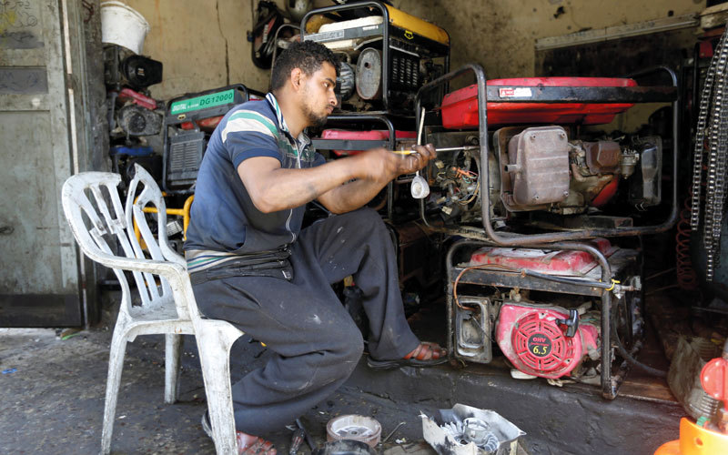 رجل يصلح مولدات كهرباء في خان يونس حيث تقلصت فترة الإمداد بالكهرباء من خمس إلى ثلاث ساعات يومياً في غزة. رويترز