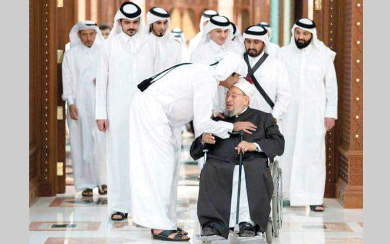 أمير قطر يقبل رأس القرضاوي في لقطة حميمية.  أرشيفية