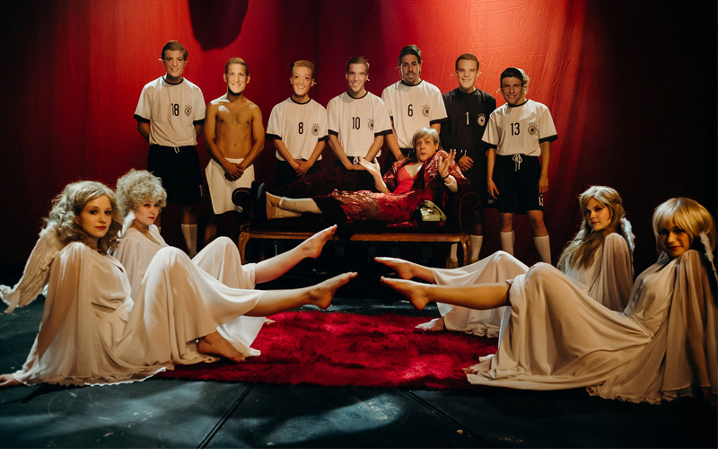 مع فنانين يضعون أقنعة لوجوه مجموعة من لاعبي المنتخب الألماني