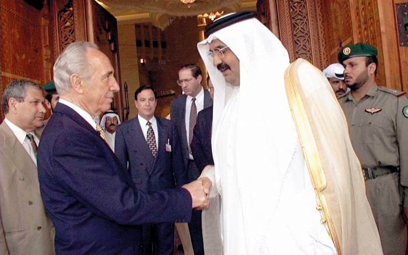 أمير قطر السابق حمد بن خليفة خلال مصافحة حميمة مع شمعون بيريز في الدوحة. أرشيفية