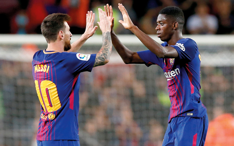 ميسي وديمبلي يحتفلان بعد الفوز الثمين على اسبانيول. رويترز