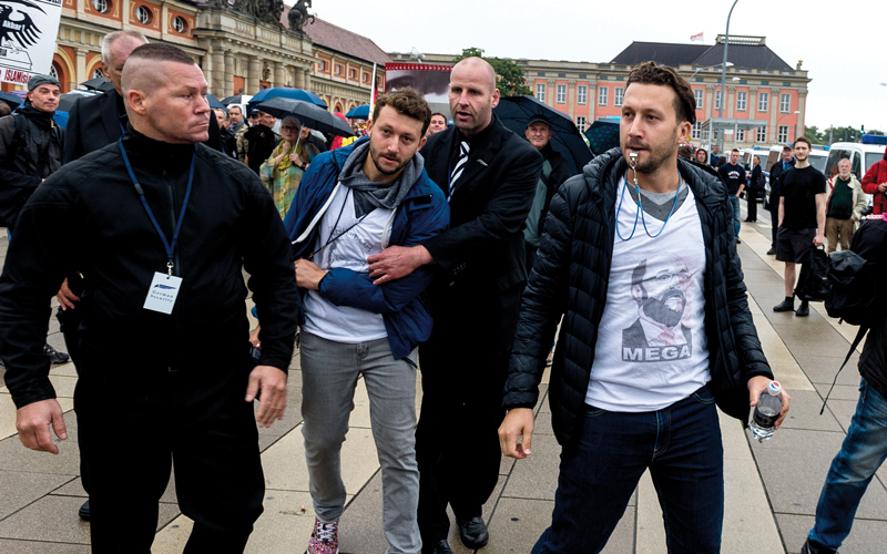 رجال الأمن يعتقلون أفراداً من حزب «البديل من أجل ألمانيا» إثر قيامهم بتظاهرة في بوتسدام. غيتي