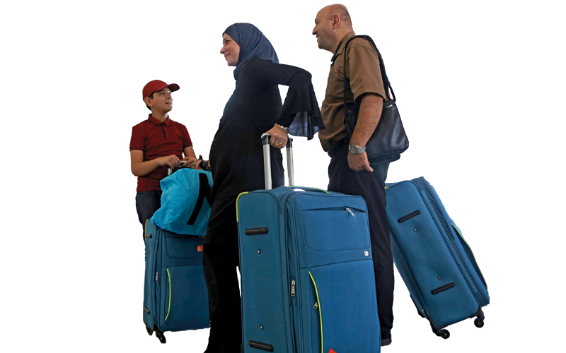 عائلة كردية تبدو في عجلة من أمرها للّحاق برحلة الطائرة قبل بدء سريان الحظر الجوي الدولي من وإلى الإقليم. إي.بي.إيه