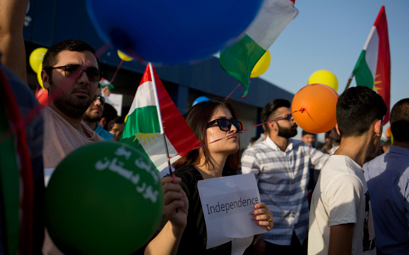 سيدة كردية تحمل لافتة كتب عليها «استقلال» خلال الاحتفال بنتيجة الاستفتاء  الذي نظّم في إقليم كردستان العراق أخيراً.  أ.ب