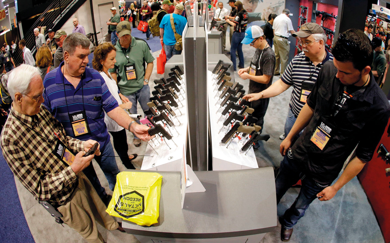 أميركيون يتفقدون المعروضات من الأسلحة النارية حيث أسهمت سهولة امتلاكها في انتشارها بشدة بين السكان. أرشيفية