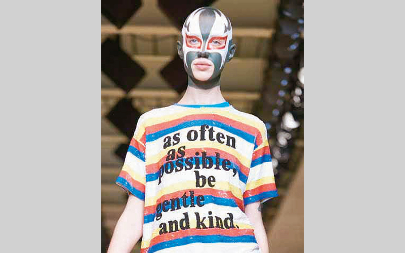 تي شيرت من تصميم أشيش عليه عبارة تحث على الرفق بالمهاجرين. غيتي