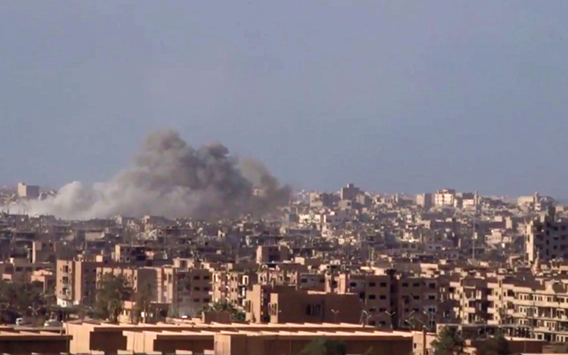 الدخان يتصاعد نتيجة قصف قوات النظام لدير الزور وقتالها لعناصر «داعش». أ.ب