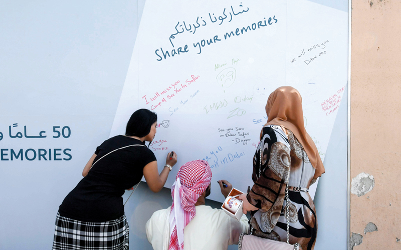 زوّار يودّعون الحديقة على لوحة تذكارية. الإمارات اليوم