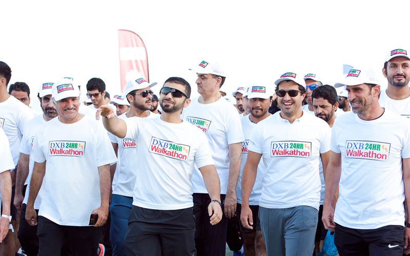 منصور بن محمد خلال مشاركته في مسيرة «دبي للمشي 24 ساعة». من المصدر