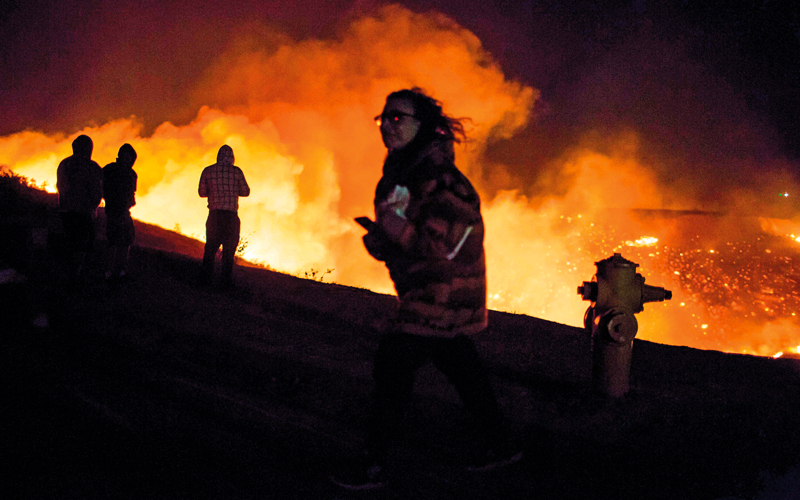 سكان المناطق الذين شرّدهم الحريق يراقبون المشهد.  أ.ف.ب
