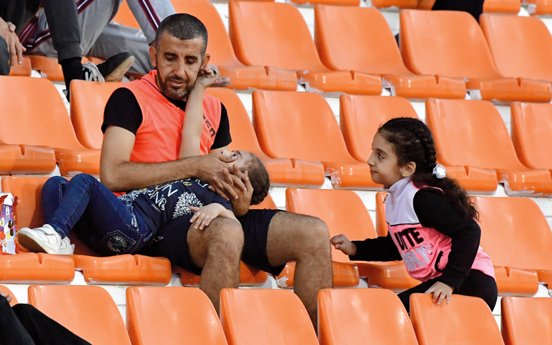 أب اصطحب عائلته إلى مدرجات إستاد عجمان، لمتابعة مباراة عجمان وحتا، التي انتهت بفوز البرتقالي بهدف دون رد. تصوير: أسامة أبوغانم
