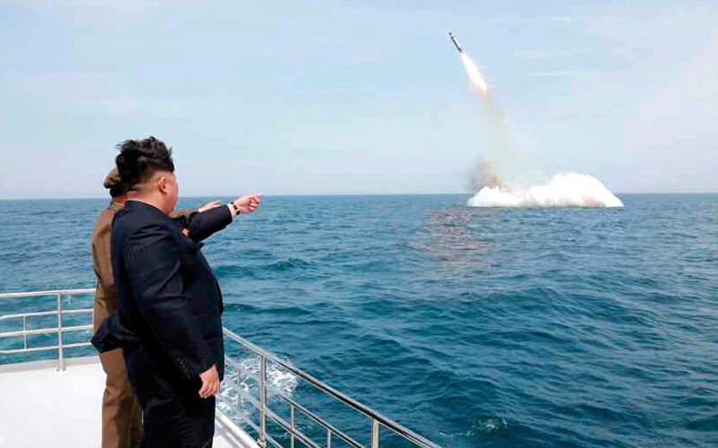 الرئيس الكوري الشمالي يشير إلى صاروخ بالستي ينطلق من تحت المياه. إي.بي.إيه