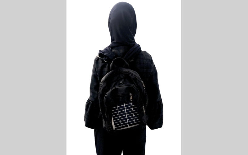 فاطمة الكعبي تحمل حقيبة الرحلات الشمسية على ظهرها. من المصدر