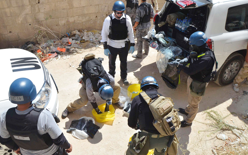 موظفو الأمم المتحدة يجمعون عينات من موقع في الغوطة الشرقية تعرض لهجوم بغاز السارين. رويترز