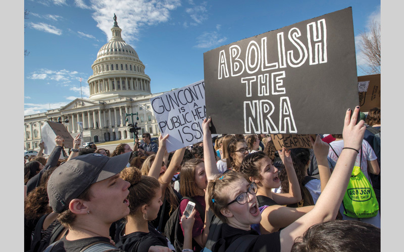 بعض المتظاهرين الأميركيين يحملون لافتة تدعو إلى إلغاء الرابطة الوطنية للأسلحة النارية.. وهي الرابطة التي تروِّج حق امتلاك الأسلحة النارية. أ.ب