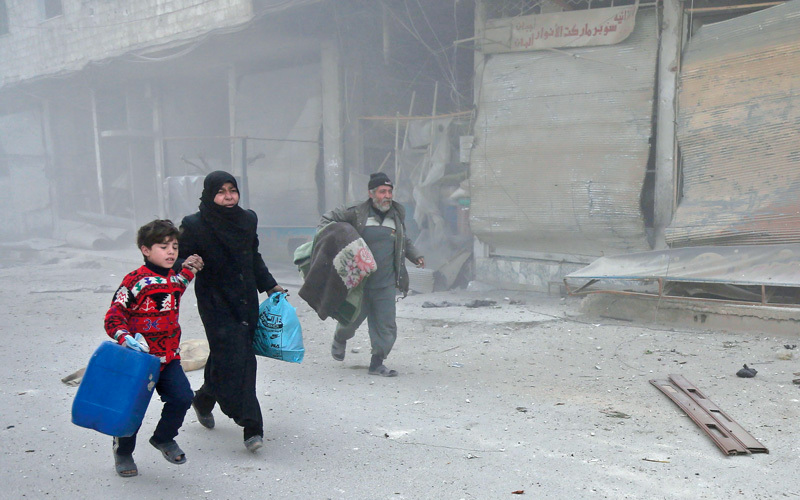 مواطنون يفرّون بحثاً عن ملجأ بعد غارات النظام السوري على الغوطة الشرقية. أ.ف.ب