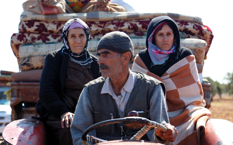 سوريون في نقطة تفتيش على حدود تركيا بعد نزوحهم من عفرين. أ.ف.ب