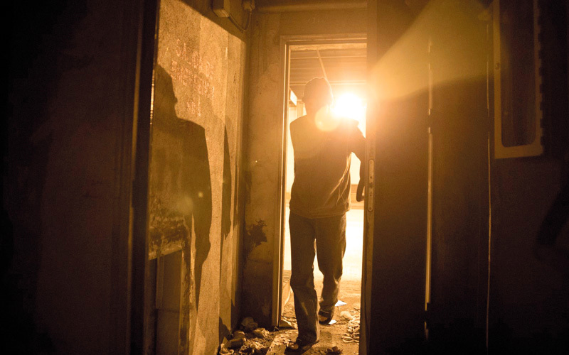 أحد المشردين يضيء شمعة في بوابة مخرج الطوارئ. غيتي