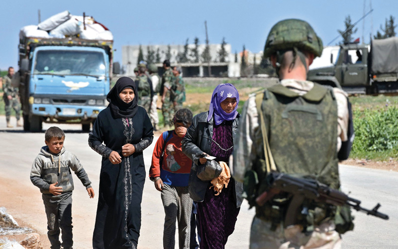 عائلات سورية نازحة لدى وصولها إلى نقطة تفتيش أبوالضهور. أ.ف.ب