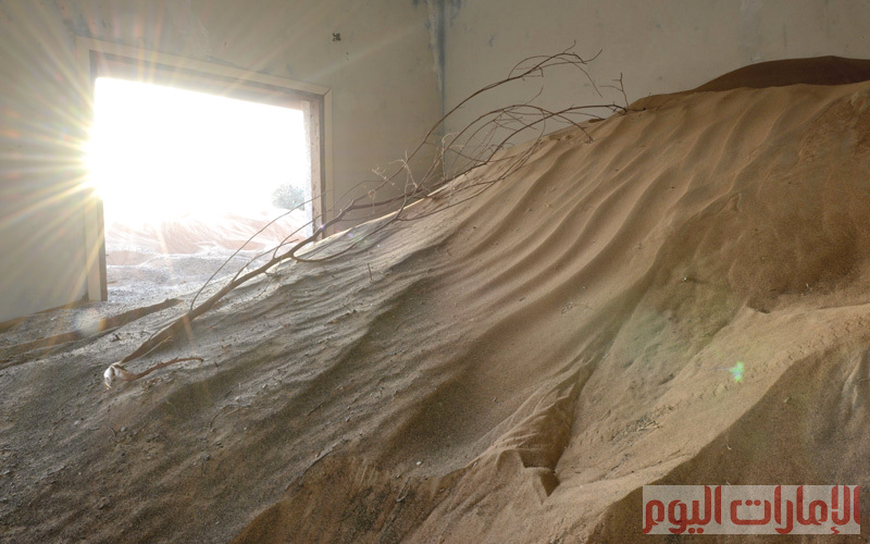 ويمكن للزائر إلى هذه المنطقة الدخول إلى تلك البيوت المهجورة عبر المشي على الكثبان الرملية التي ارتفعت أكثر من أسوار البيوت، ووصلت حتى السقوف. تصوير: يوسف الهرمودي