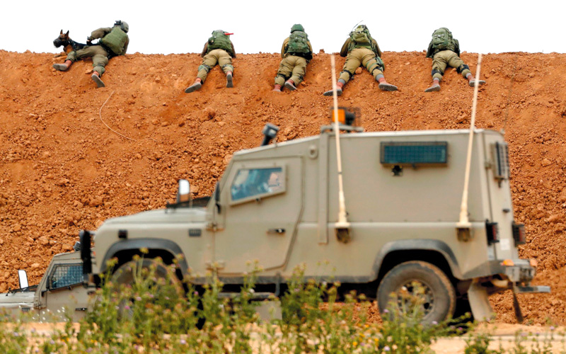 جنود إسرائيليون يطلقون قنابل الغاز المسيل للدموع والرصاص الحي على المتظاهرين.  أ.ف.ب