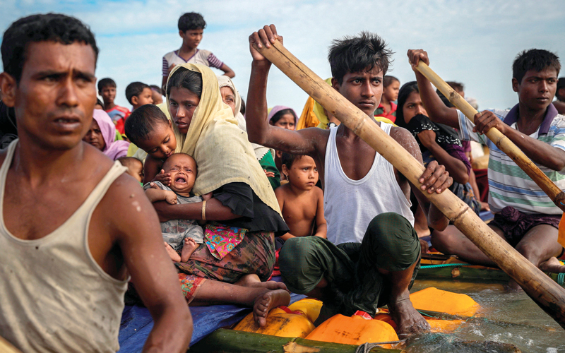 لاجئون ا يستقلون قارباً متهالكاً للوصول إلى بنغلاديش.  رويترز