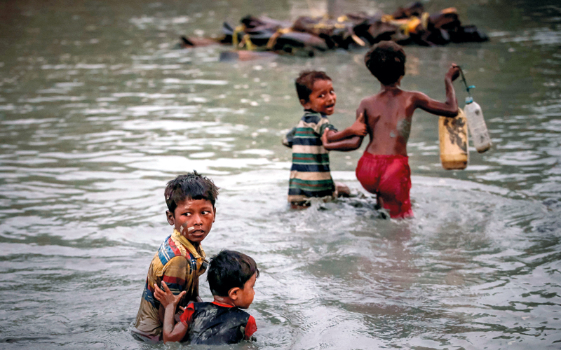 أطفال يهربون فزعاً جراء العنف عبر نهر ناف الفاصل بين ميانمار وبنغلاديش.  رويترز