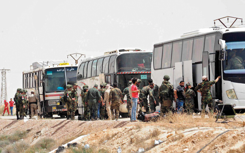 جنود روس وسوريون يفتشون أحد المواقع التي تركتها ميليشيات جيش الإسلام بعد رحيلها من منطقة الضمير. أ.ب