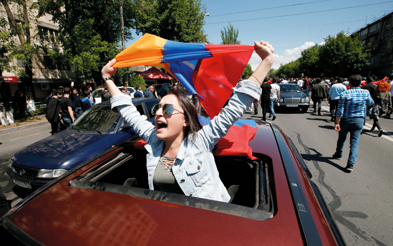 سيدة تحمل علم ارمينيا اثناء مشاركتها في الاحتجاجات. رويترز