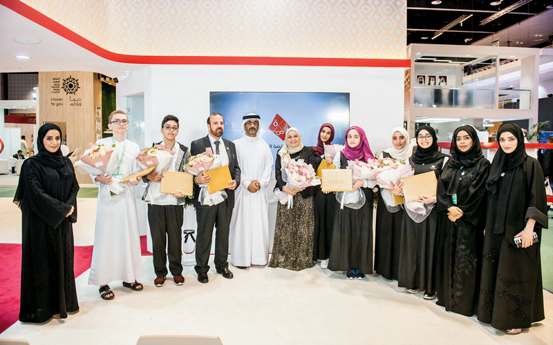 صورة جماعية للفائزين بمسابقة القصة القصيرة وفرق العمل يتوسطهم بن دلموك الرئيس التنفيذي لمركز حمدان. الإمارات اليوم
