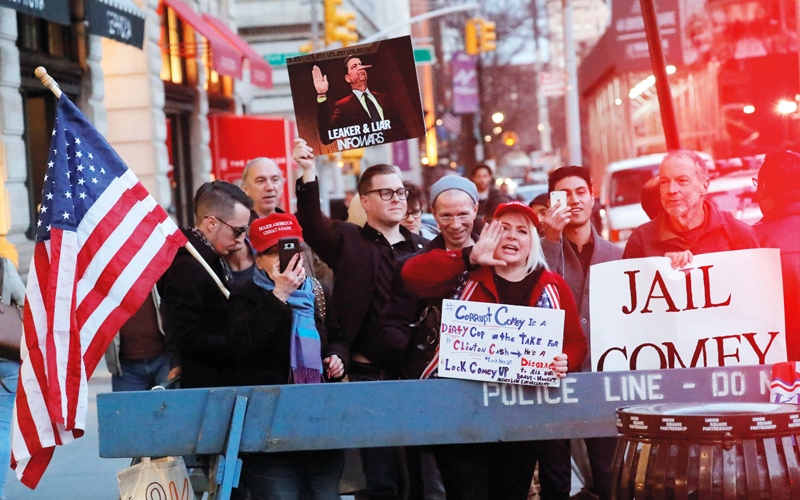 متظاهرون مؤيدون لترامب يتوعّدون كومي بالسجن. رويترز