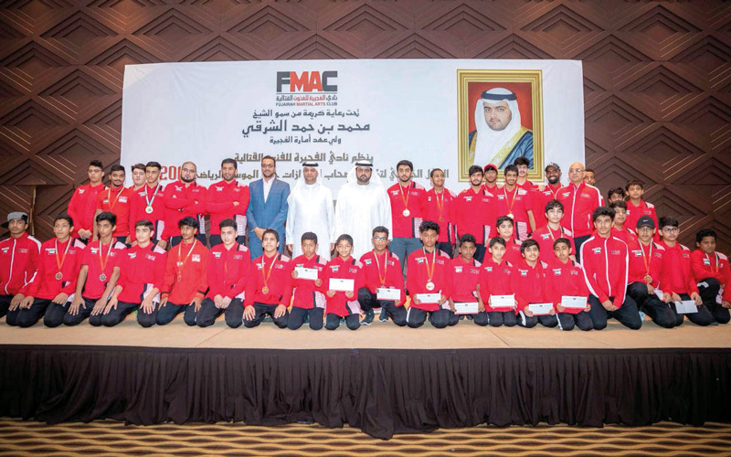 محمد بن حمد بن محمد الشرقي يتوسط أبطال الفنون القتالية بنادي الفجيرة. من المصدر