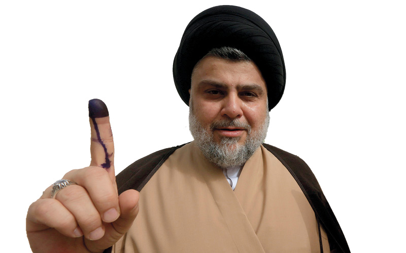 مقتدى الصدر رافعاً إصبعه بعد التصويت في الانتخابات. رويترز