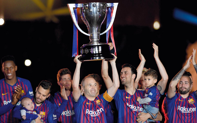 إنييستا يرفع كأس الدوري الإسباني في نهاية مشواره الكاتالوني. أ.ف.ب