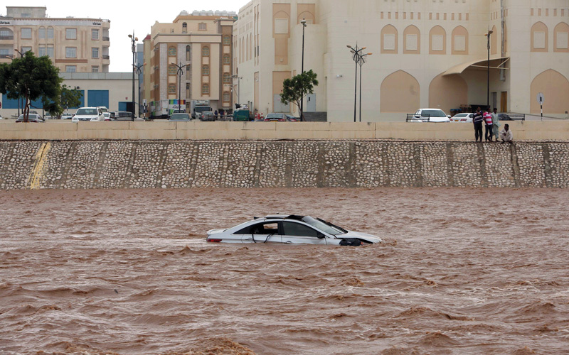سيارة غارقة في شارع غُمر جراء الفيضانات بمدينة صلالة. أ.ف.ب