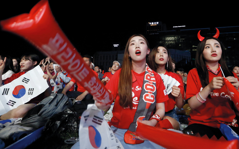 مشجعات لكوريا الجنوبية يتابعن منتخب بلادهن عبر التلفاز. إي.بي.إيه