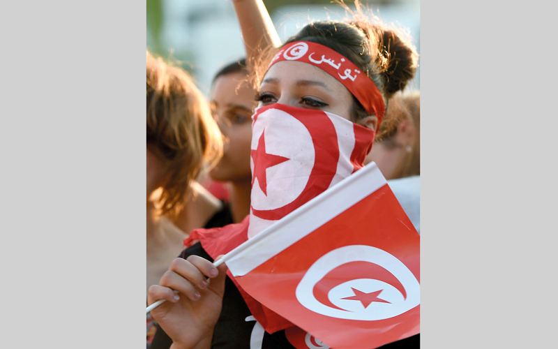 فتاة تونسية توشحت بعلم بلادها، خلال تشجيع «نسور قرطاج» أمام إنجلترا. أ.ف.ب