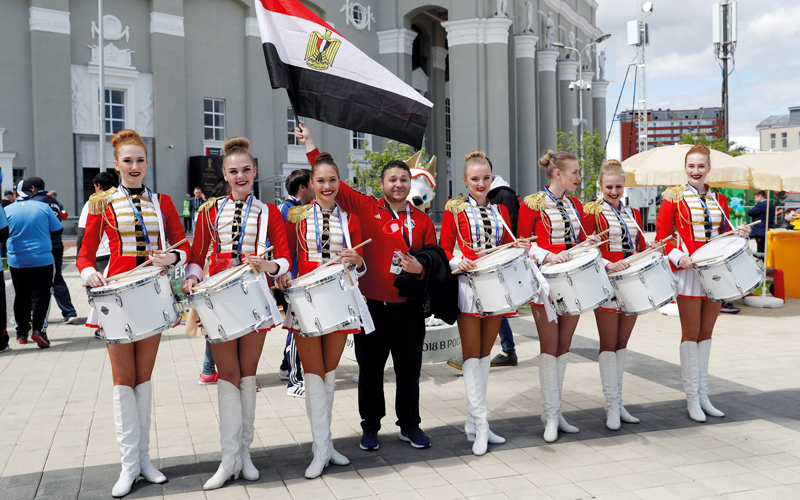 مشجع مصري يرفع علم بلاده، يتوسط  مجموعة من الفتيات قبل مباراة مصر وروسيا  التي أقيمت أمس في انطلاق الجولة الثانية من المونديال. رويترز