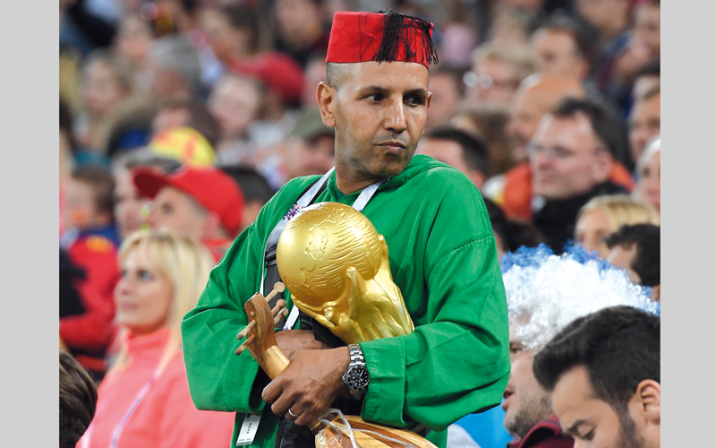 مشجع مغربي يحمل مجسَّم كأس العالم أثناء تشجيع منتخب بلاده أمام إسبانيا. أ.ف.ب