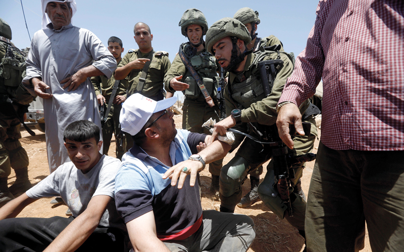 جنود إسرائيليون يتعاملون بقسوة مع متظاهرين فلسطينيين يتظاهرون ضد المستوطنات في الضفة الغربية.  إي.بي.إيه