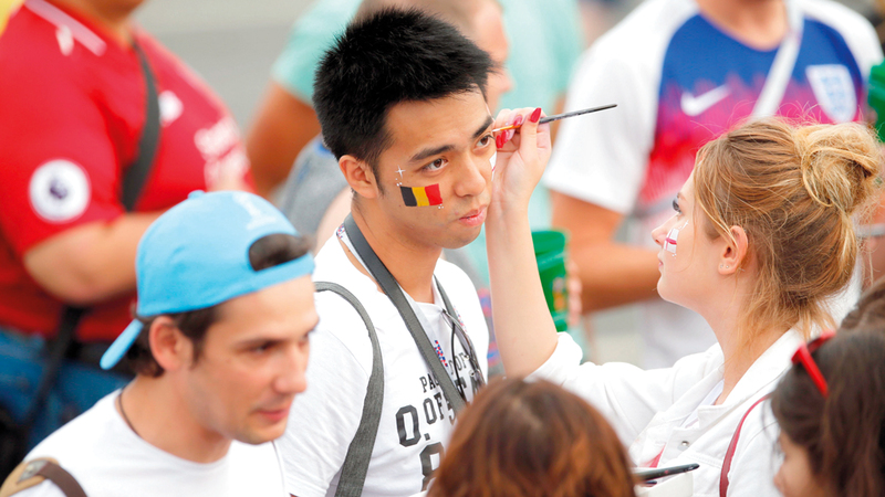 مشجعة ترسم على وجه مشجع بلجيكي في مدرجات ملعب سانت بطرسبرغ.

أ.ف.ب