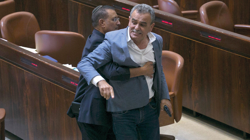 النائب العربي في «الكنيست» الإسرائيلي جمال زحالقة أثناء طرده من قاعة البرلمان بعد احتجاج النواب العرب على تبني القرار العنصري. أ.ب