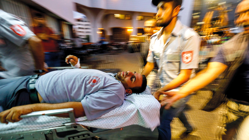 أحد الجرحى الفلسطينيين خلال نقله إلى مستشفى الشفاء في غزة.  أ.ف.ب