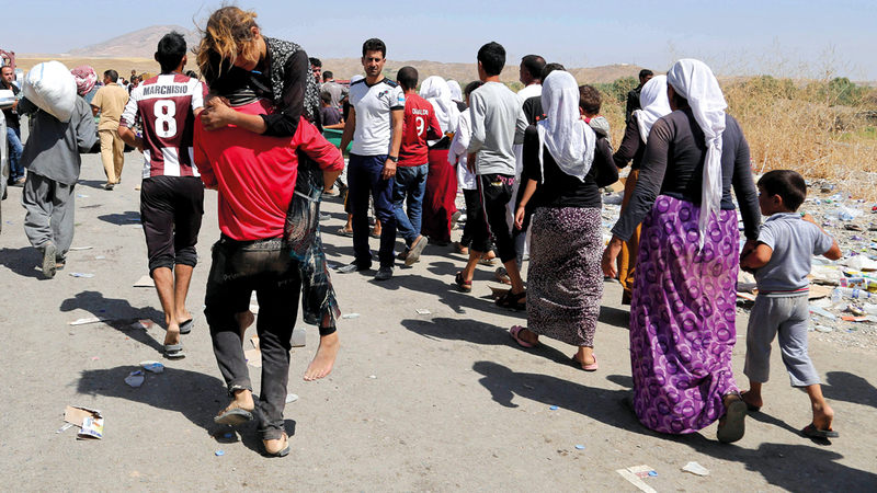 أيزيديون يعبرون الحدود العراقية السورية هرباً من القتال في شمال العراق. أ.ب