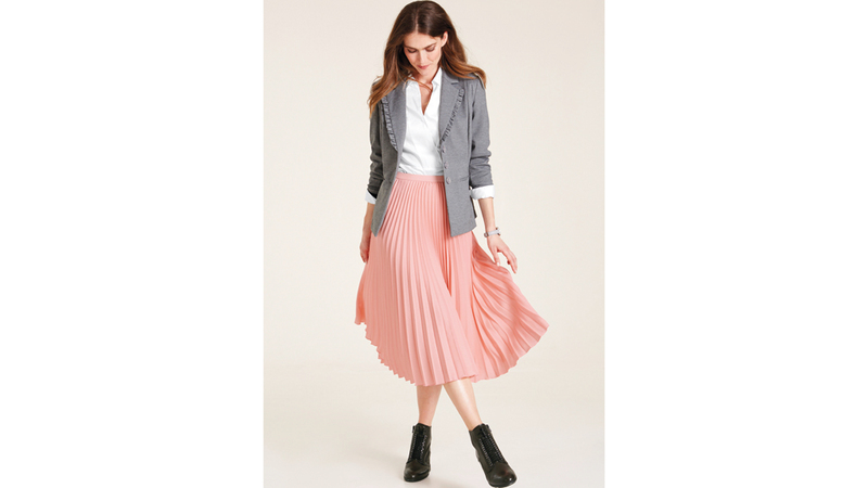 لإطلالة عمل أنيقة يمكن تنسيق التنورة متوسطة الطول مع بلوزة بسيطة وبليزر. د.ب.أ