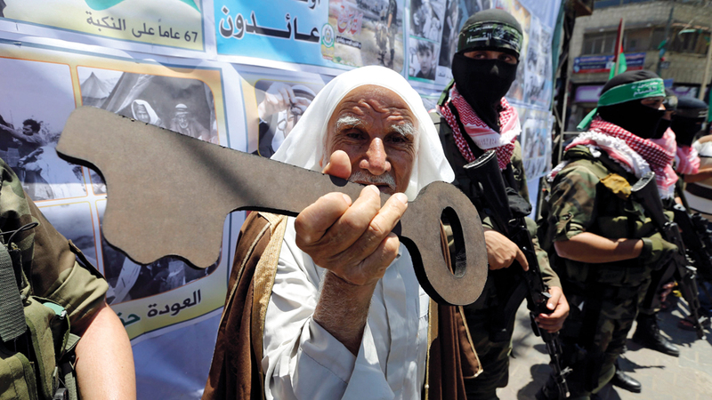 فلسطيني يمسك بمجسم مفتاح تأكيداً لحق العودة خلال مسيرة في رفح.

أرشيفية